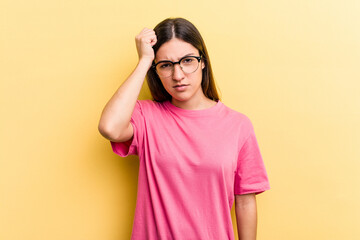 Young caucasian woman isolated on yellow background tired and very sleepy keeping hand on head.