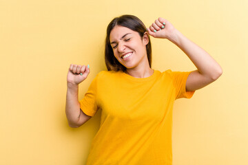 Young caucasian woman isolated on yellow background celebrating a special day, jumps and raise arms with energy.