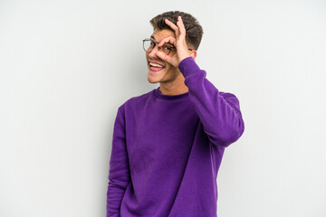 Young caucasian man isolated on white background excited keeping ok gesture on eye.