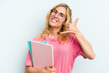 Young student caucasian woman holding books isolated on blue background showing a mobile phone call gesture with fingers.