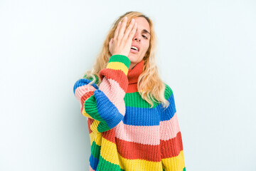 Young caucasian woman isolated on blue background tired and very sleepy keeping hand on head.