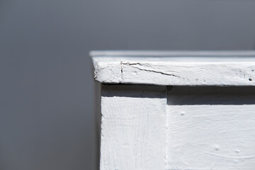 profile of an rustic vintage wooden white stool on a gray background close-up
