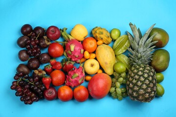 Naklejka na ściany i meble Assortment of fresh exotic fruits on light blue background, flat lay