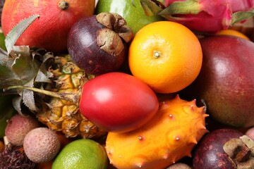 Naklejka na ściany i meble Different delicious exotic fruits as background, top view