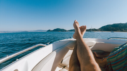 First person view of a man relaxing on a boat - obrazy, fototapety, plakaty