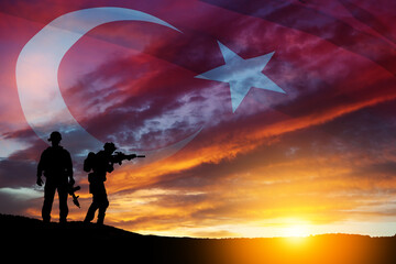 Fototapeta premium Silhouettes of soldiers on a background of Turkey flag and the sunset or the sunrise. Concept of crisis of war and conflicts between nations. Greeting card for Turkish Armed Forces Day, Victory Day.