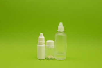 Empty jars, tubes, bottles on a green background