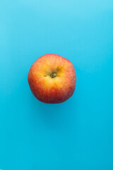 Juicy red apple on blue background, subject food shot
