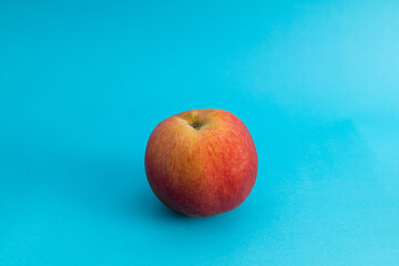 Juicy red apple on blue background, subject food shot