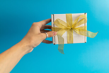 A girl is holding a white gift box