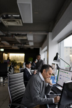 Focused Male Graphic Designer Using Graphics Tablet At Desk In Office