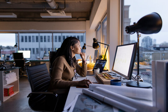 Female Architect Working At Computer In Urban Office