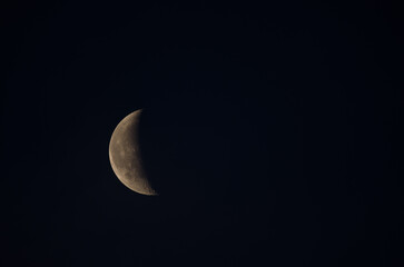 Last quarter of the moon half-covered by the clouds. Las Palmas de Gran Canaria. Gran Canaria....