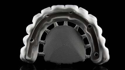 Dendal photo of the milling dental of Zircon for the future prosthesis of the upper jaw with a hole for a titanium beam on a black background © Dental Pro Content
