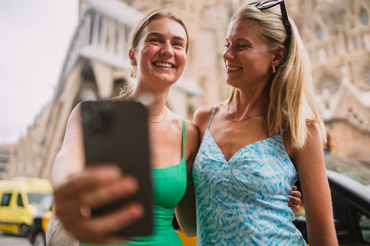 Happy friends enjoying her trip in Barcelona while taking pictures and selfies.