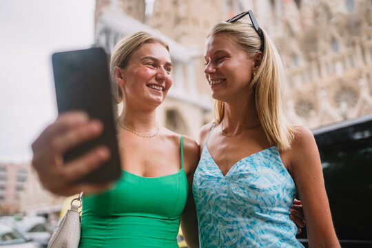Happy friends enjoying her trip in Barcelona while taking pictures and selfies.