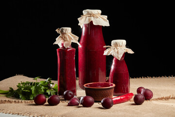Red sauce for meat in craft glass bottles. Tkemali from plums