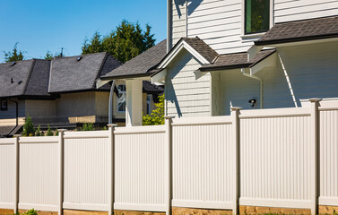 Nice wooden fence around house. Wooden fence with green lawn.