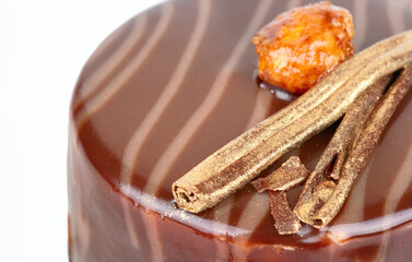 Piece of chocolate brownie with salted caramel and cookies inside. Decorated with nuts around the edges.