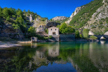 Fototapeta na wymiar Hermitage and lake of San Domenico in Abruzzo, Italy. Small church of medieval origin which is reflected on the lake's waters.
