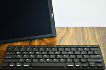 Tableta y teclado inalambrico sobre un escritorio de trabajo.