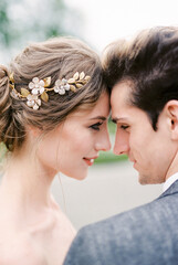 Groom touches the forehead of bride with his forehead. Portrait