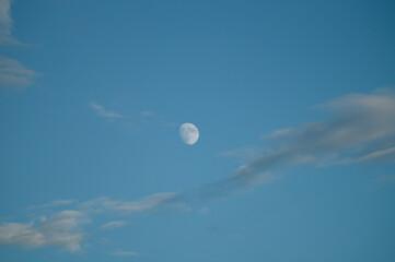 Full moon in the blue sky among beautiful clouds
