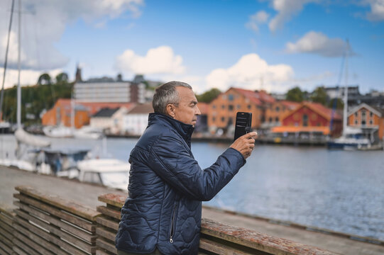attractive old man walking in the city  lifestyle portrait with Tonsberg viewpoint