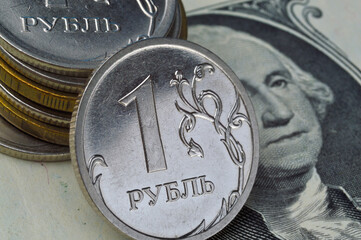 Russian 1 ruble coins lie on an American 1 dollar banknote
