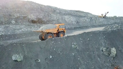 Dump truck loaded with chalk moving on a quarry road. Quarry and mining equipment.