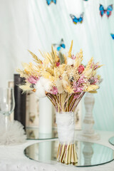 Dried cotton flowers and wheat ear in a bohemian bridal bouquet,