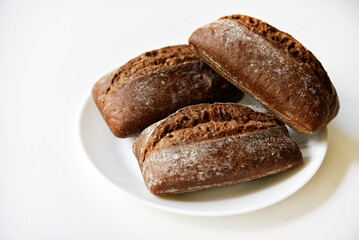 Rye bread from a hypermarket on a white plate. Delicious and beautiful bread macrophoto.