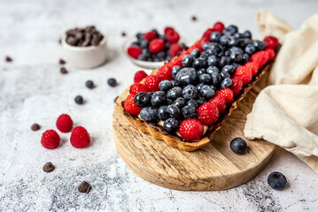 Fruit Tart full of Berries with chocolate and cream on cookie crust. European dissert. 