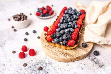 Fruit Tart full of Berries with chocolate and cream on cookie crust. European dissert. 