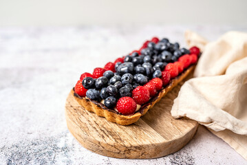 Fruit Tart full of Berries with chocolate and cream on cookie crust. European dissert. 