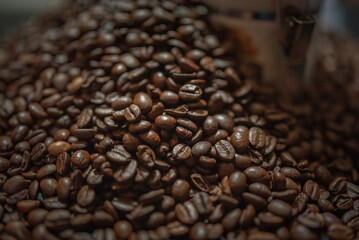 Grains of delicious roasted coffee in a manual mechanical coffee grinder.