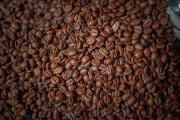 Grains of delicious roasted coffee in a manual mechanical coffee grinder.