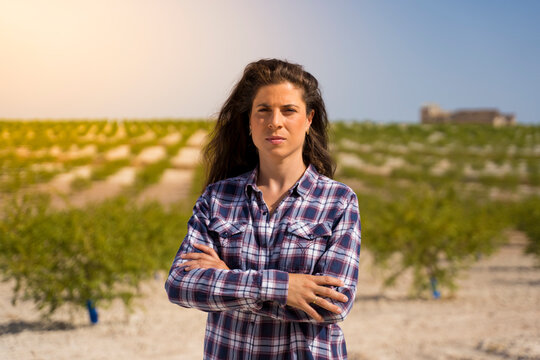 hardworking farmer woman in a plaid shirt and long brunette hair