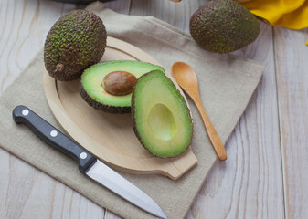 Aguacate cortado por la mitad en dos trozos sobre la mesa