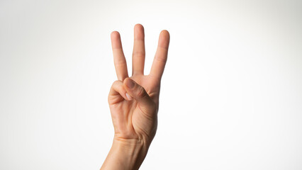 Women's hands gesture counting on fingers three palm side
