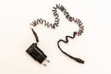 Charred charger wire, close-up. White background. Flat lay. Short-circuited and fire concept