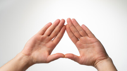 The man's palms are folded in a triangle on a white background