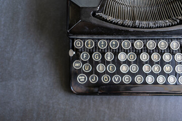 Selective focus. Top view of an old vintage typewriter on gray table.. Noise effect and grainy...