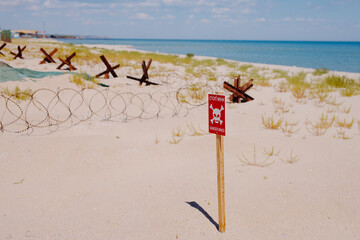 Danger. Mines and anti-tank hedgehogs at the beach, war in Ukraine 2022