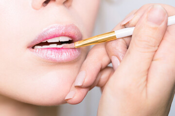 Makeup lips closeup. Makeup in the process of applying lipstick.