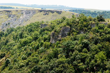 Fototapeta premium Beautiful natural gorge strewn with hills, grass and trees. Stunning landscape for tourism