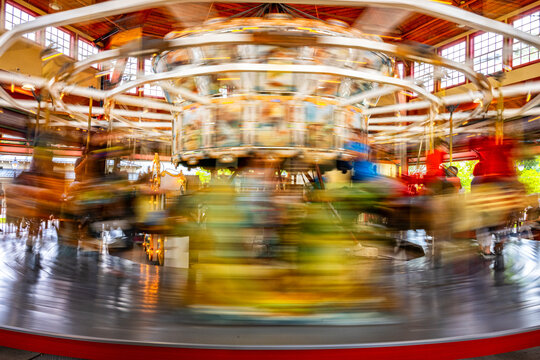 Long speed blur image of Carousel with unrecognized people, beautiful colorful light spinning games 