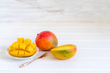 Fresh mango fruit on white wooden background.