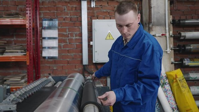 Worker measuring the necessary length of the fabric for bag manufacturing. Worker measuring fabric for eco-friendly bags. Worker measuring sustainable fabric textile at the factory.