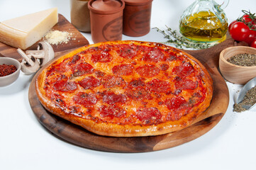 Pepperoni pizza with tomato, onion, chili powder, and black pepper isolated on wooden cutting board side view of fastfood on wooden table